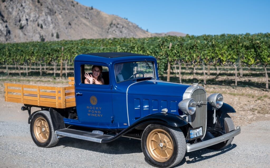 bride and groom driving vintage blue rocky pond truck